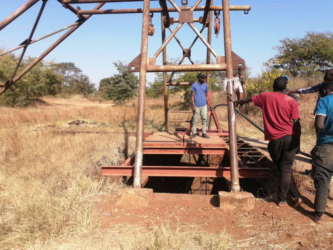 People inspecting a mine shaft and its steel headgear