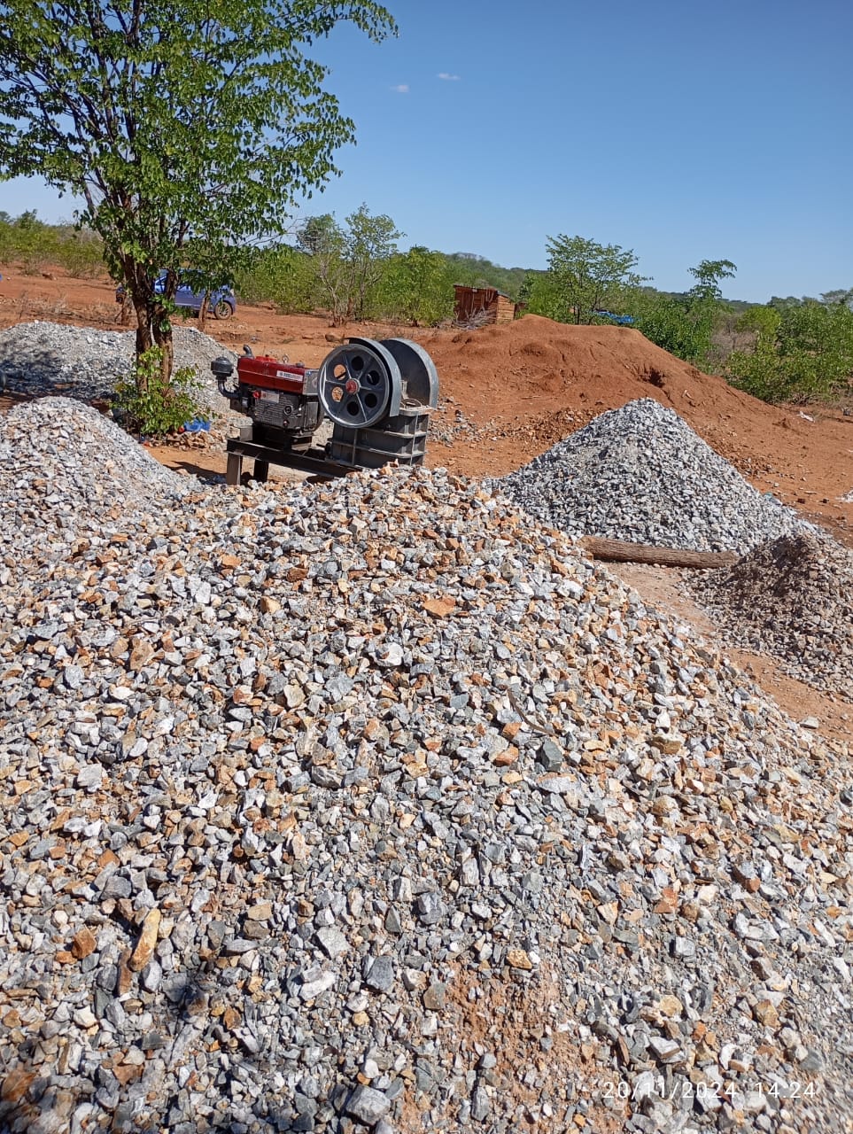 A rock crusher beside piles of broken rock at a mining site